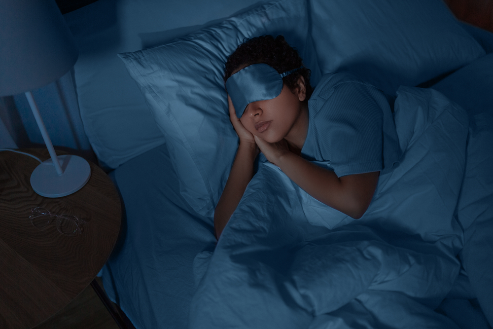 woman sleeping in bed wearing eye mask